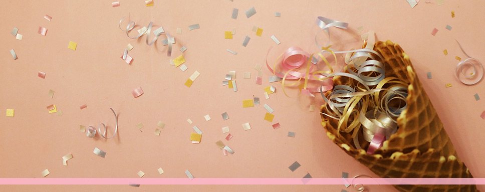 Confetti I glasstrut mot orange bakgrund, Amendo
