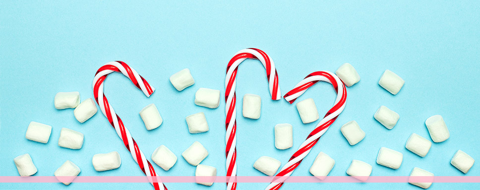 Polkagrisar och marshmallows mot blå bakgrund, god jul önskar Amendo